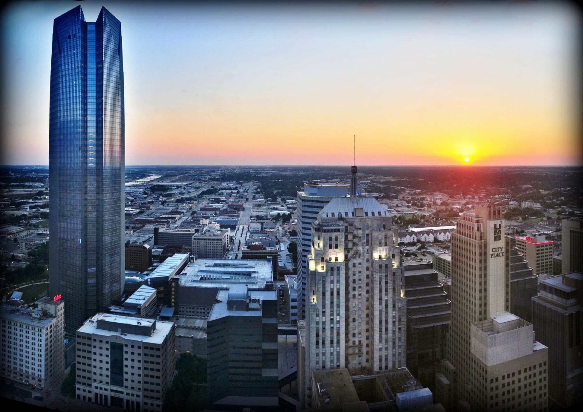 Aerial view of downtown Oklahoma City rooftops at sunset.